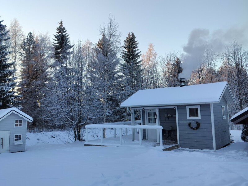 Saunamökki lumisessa maisemassa